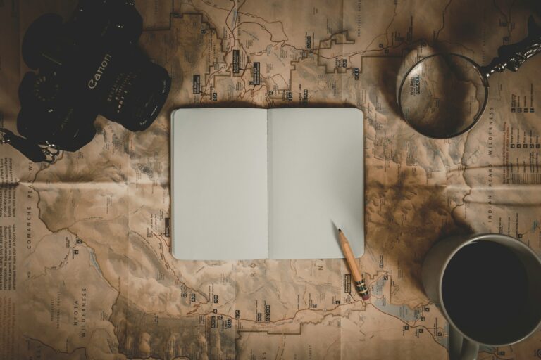 Cuaderno en blanco sobre un mapa con lápiz, simbolizando el inicio de una estrategia editorial para autores que desean publicar